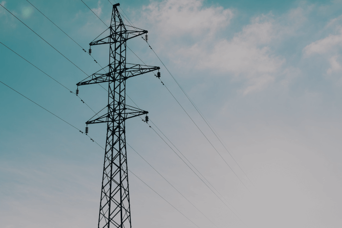 Imagem de uma torre de transmissão de energia sobre ceu aberto